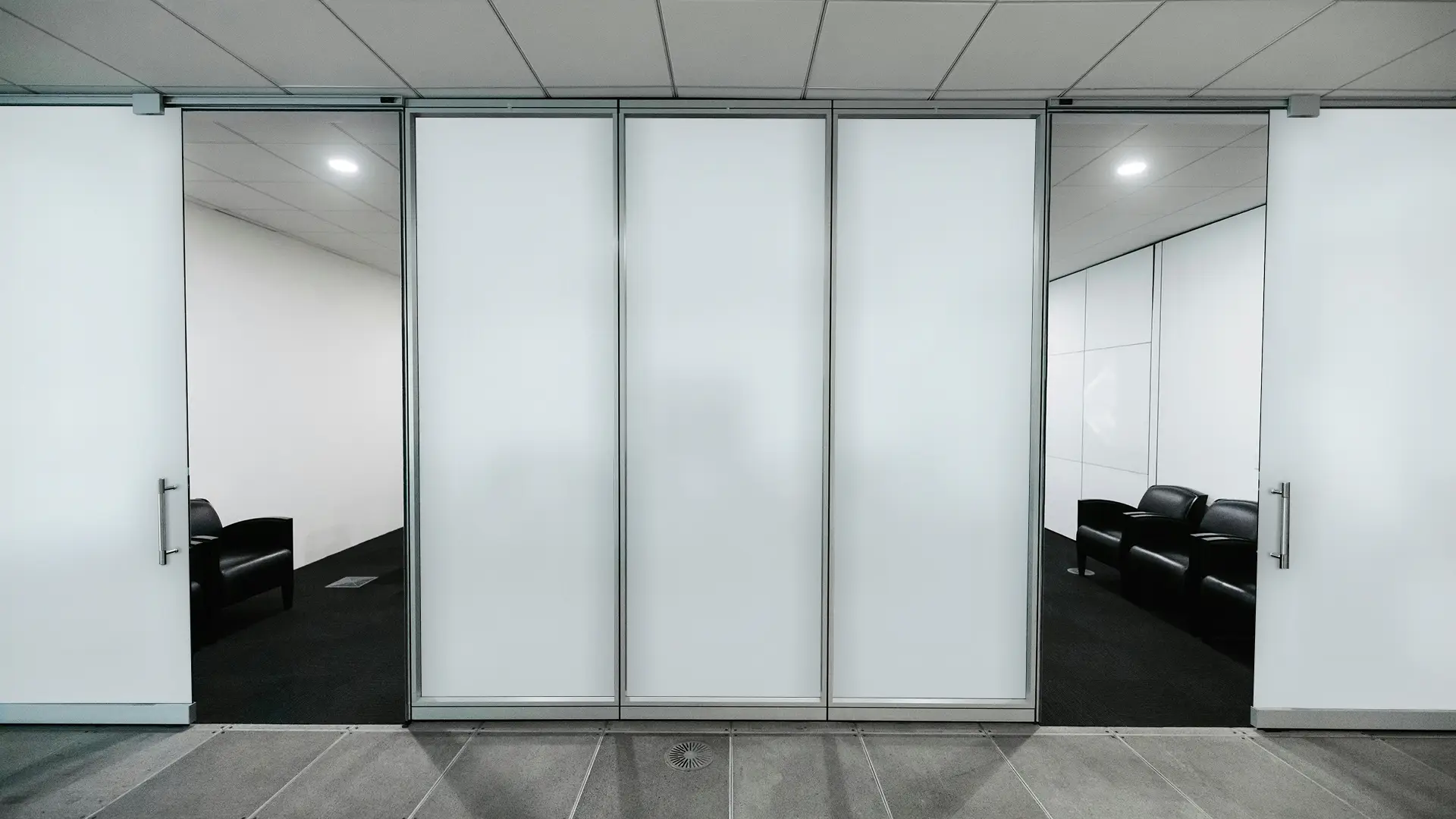 Commercial workspace with electronic smart glass walls activated for privacy.