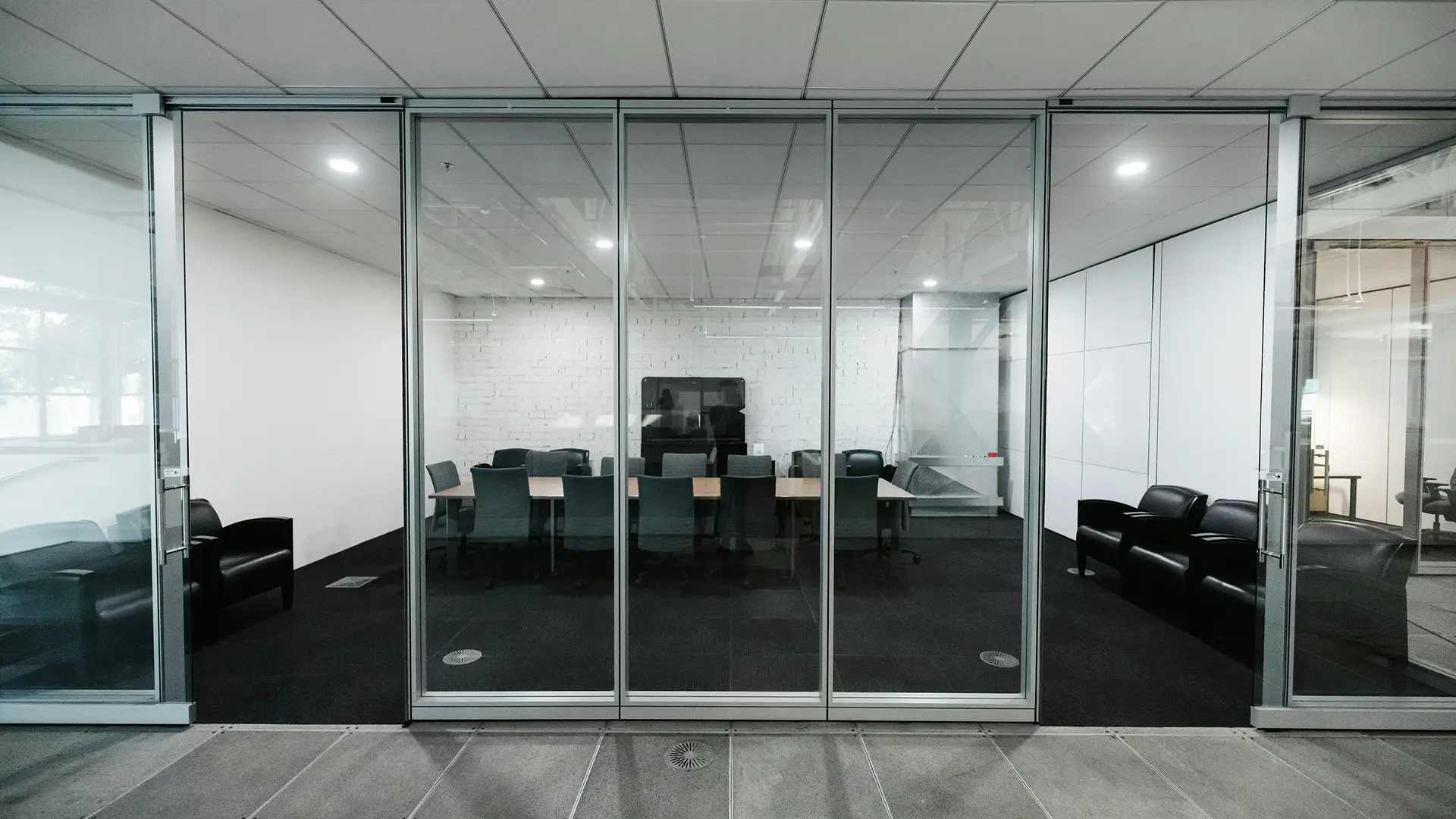 Commercial office space with floor-to-ceiling clear glass walls.