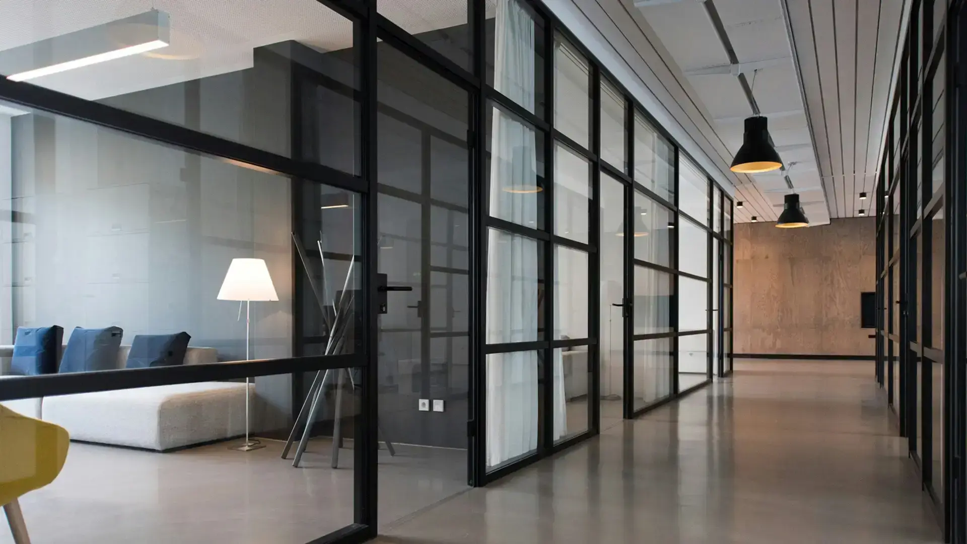 Modern office conference room with transparent smart glass partitions allowing visibility.